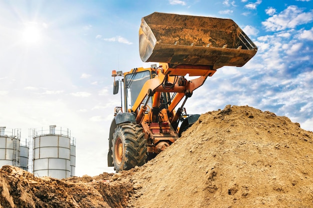 Powerful wheel loader or bulldozer working on a quarry or construction site Loader with a full bucket of sand Powerful modern equipment for earthworks