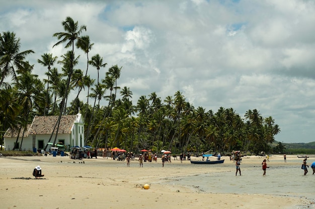 Praia dos Carneiros Pernambuco Brazil November 09 2022 Small church facing the beach with tourists