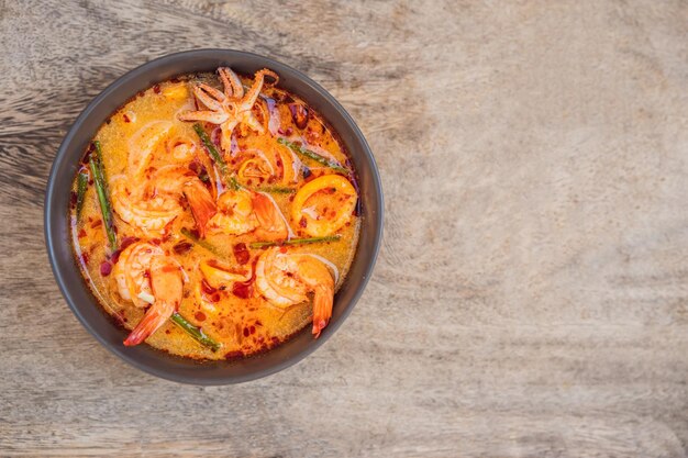 Prawn and lemon grass soup with mushroomstom yam kung thai food in wooden background top view