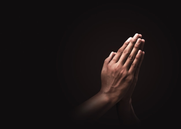 Praying hands with faith in religion and belief in God on dark . Power of hope or love and devotion. Namaste or Namaskar hands gesture. Prayer position.