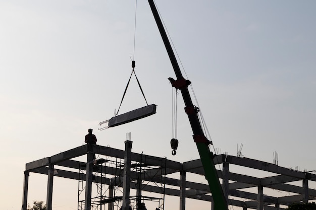 Precast concrete beam installed at construction site by mobile crane  ; civil engineering background