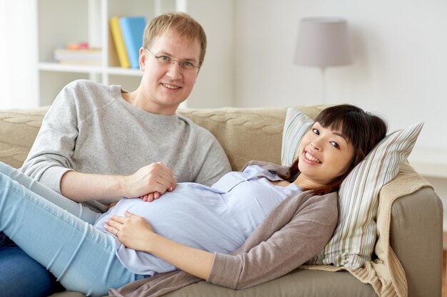 Photo pregnancy, family and people concept - happy pregnant wife with husband at home