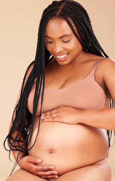 Pregnancy feeling lingerie or relax woman with studio smile happy and excited for baby stomach growth or motherhood Gynecology maternity or pregnant African model with healthcare love and hope