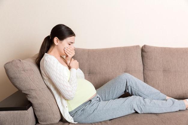 Pregnancy Morning Sickness Pregnant Woman Having Nausea Feeling Bad in Sofa at the Home