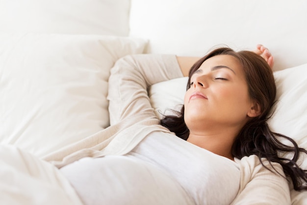 pregnancy, rest, people and expectation concept - happy pregnant woman sleeping in bed at home