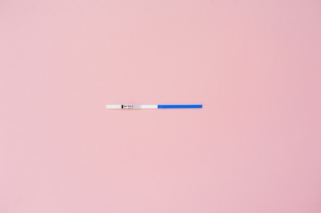 Pregnancy test isolated on pink background. Empty mock up 