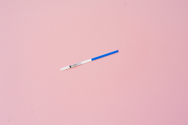 Pregnancy test isolated on pink background. Empty mock up 