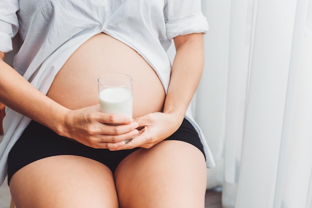 Pregnancy woman holding a glass of milk for drinking