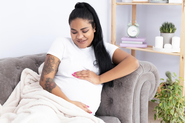 Pregnant African American woman in room on couch