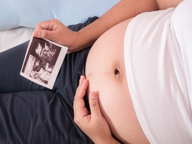 Pregnant Belly with all fingers to hold ultrasound image