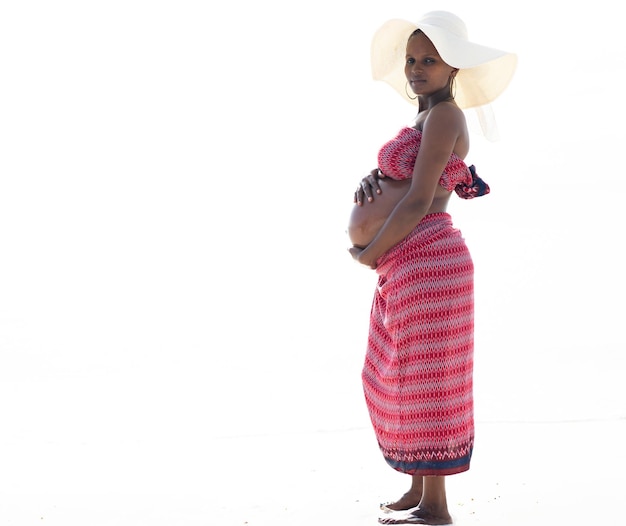 Pregnant black african woman with hat at the beach high quality photo