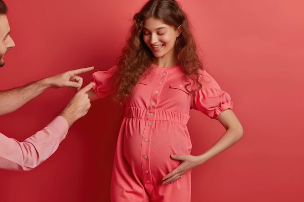 Pregnant girl chooses baby outfit at home with mans help