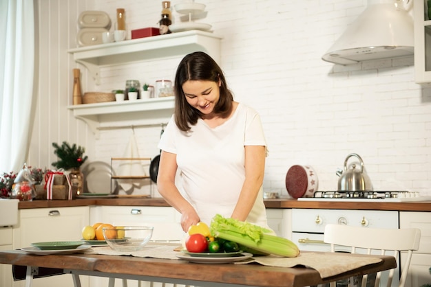 Pregnant girl cooks in the kitchen at home