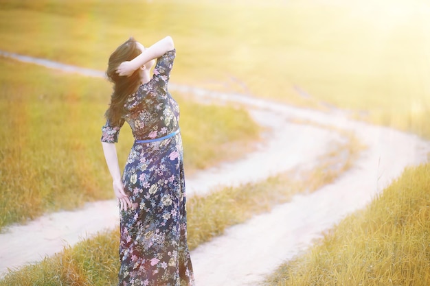 Pregnant girl in a dress in nature