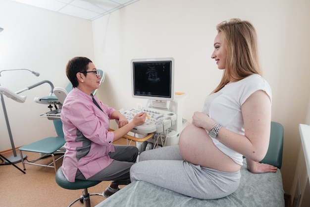 A pregnant girl is advised by a doctor after an ultrasound in the clinic. Medical examination