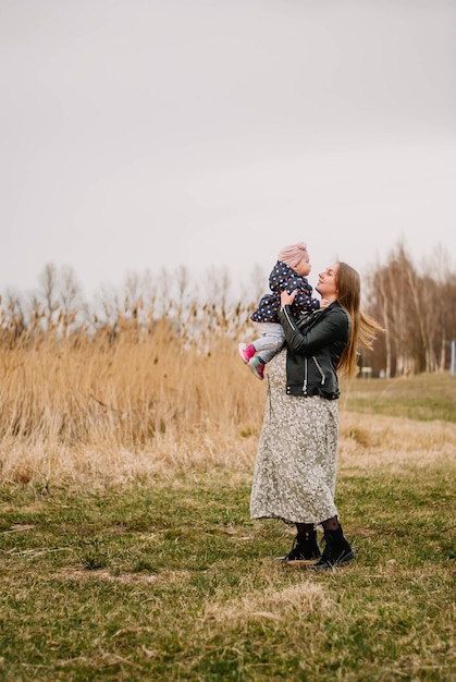 pregnant girl in nature spring lake the girl smiles happy mom mom and daughter are walking