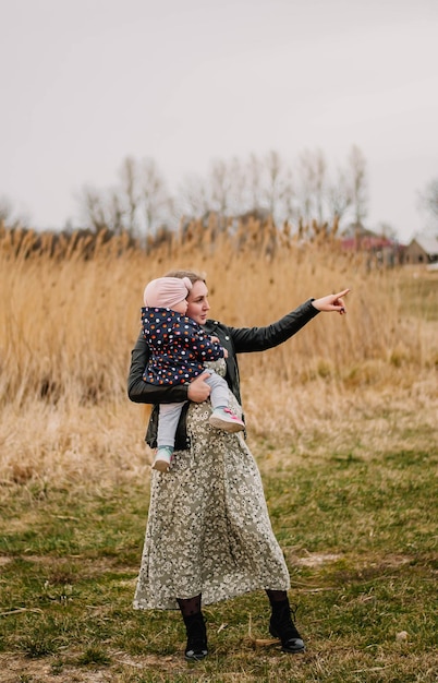 pregnant girl in nature spring lake the girl smiles happy mom mom and daughter are walking