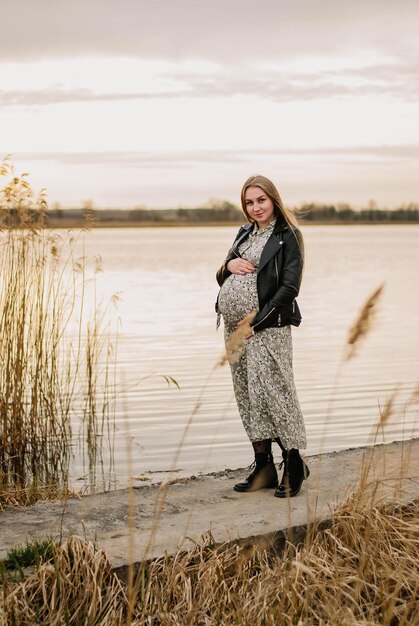 pregnant girl in nature spring reeds pregnant girl on the lake shore the girl smilesa happy mom