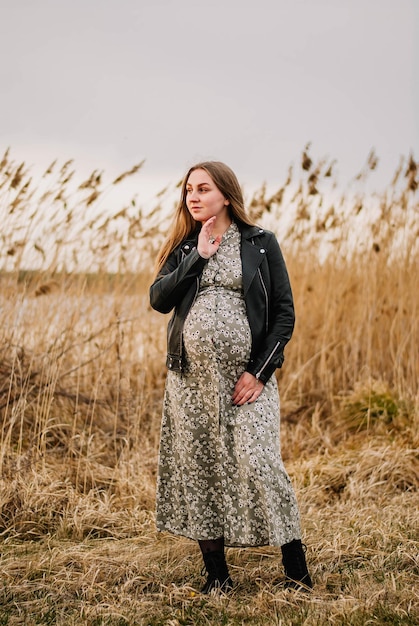 pregnant girl in nature spring reeds pregnant girl on the lake shore the girl smilesa happy mom