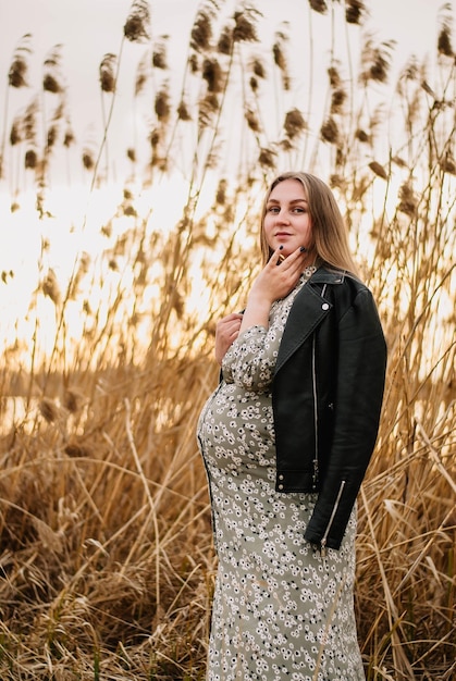 pregnant girl in nature spring reeds pregnant girl on the lake shore the girl smilesa happy mom