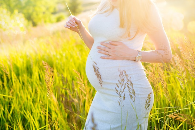 Pregnant girl walks in the field