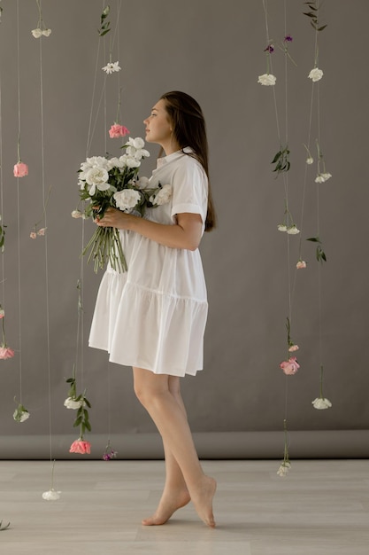 Pregnant girl in a white dress with peonies