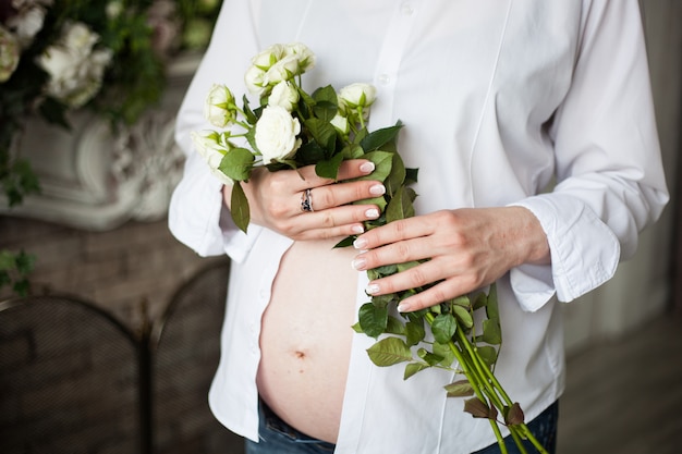 Pregnant girl, with beautiful white roses, waiting for baby, 9 months, family