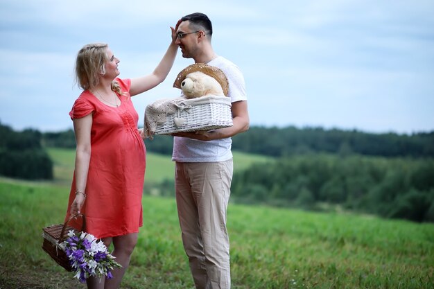 Pregnant girl with big belly and young man in park