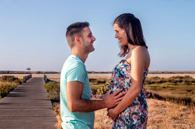 Pregnant happy couple with small dog