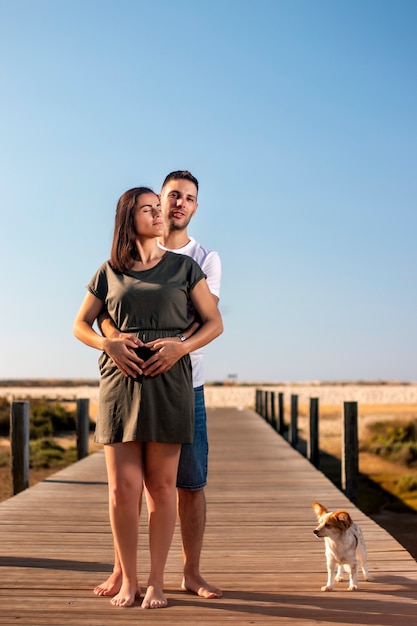 Pregnant happy couple with small dog