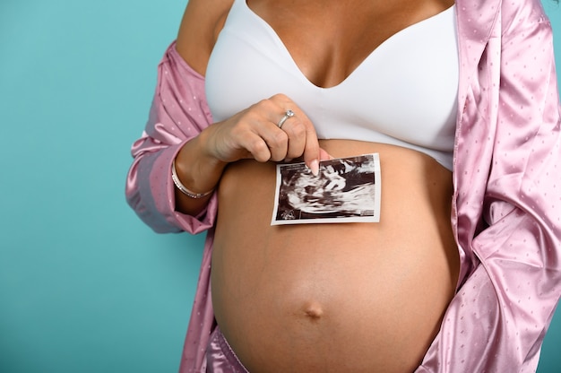 Pregnant mom shows an ultrasound of her son