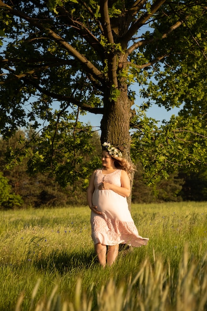 Pregnant woman on the background of a field