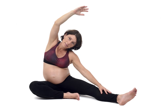 Pregnant woman doing floor exercises on white backgroun