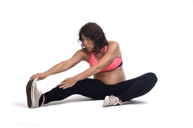 Pregnant woman doing floor exercises on white background