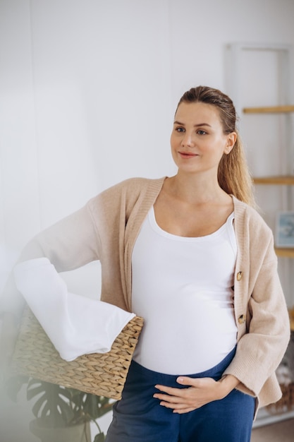 Pregnant woman doing laundry at home