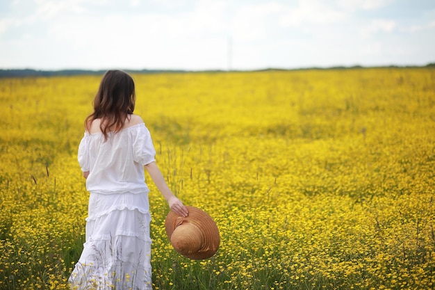 Pregnant woman in a dress in a field of flowers