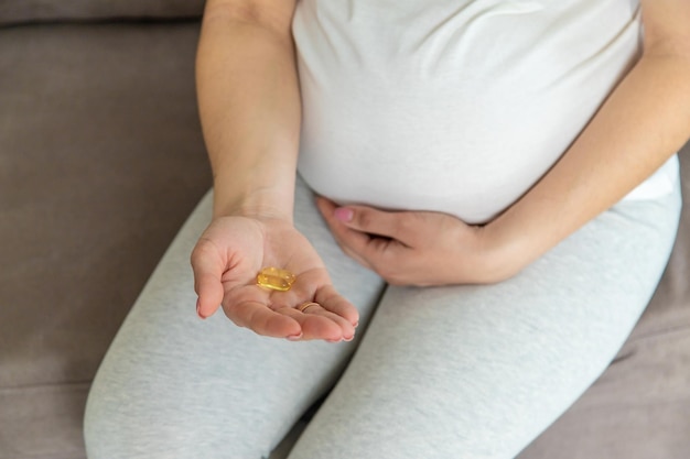 Pregnant woman drinks omega three Selective focus