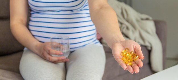 Pregnant woman drinks omega three Selective focus