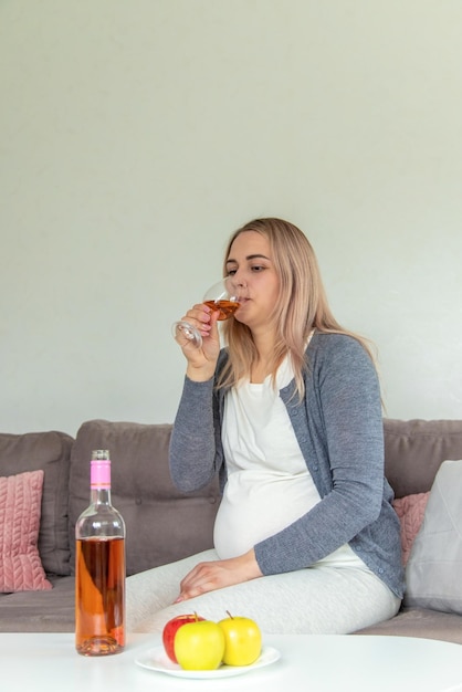 A pregnant woman drinks wine in a glass Selective focus