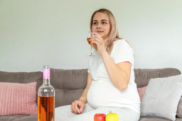 A pregnant woman drinks wine in a glass Selective focus