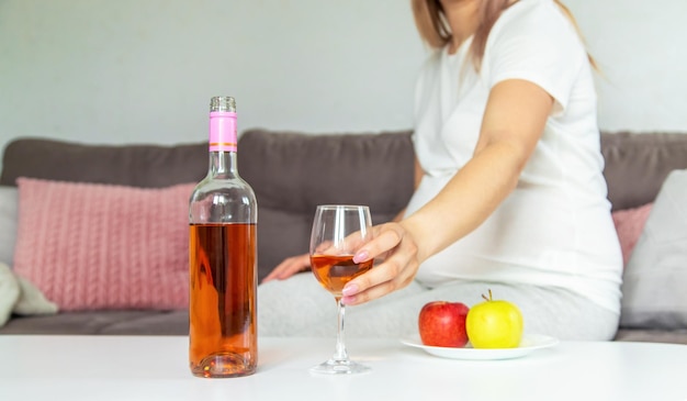 A pregnant woman drinks wine in a glass Selective focus