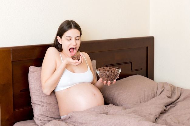 Pregnant woman eating chocolate cereal balls