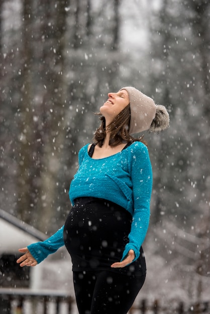 Pregnant woman enjoying snowfall