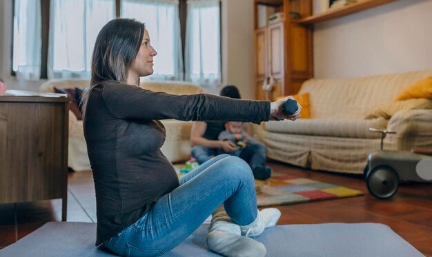 Pregnant woman exercising in the living room of her house