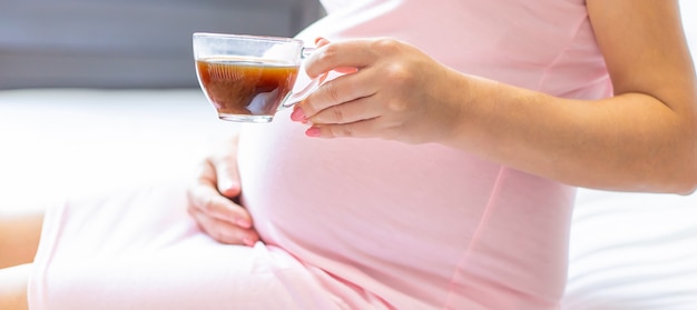 Pregnant woman holding a cup of coffee