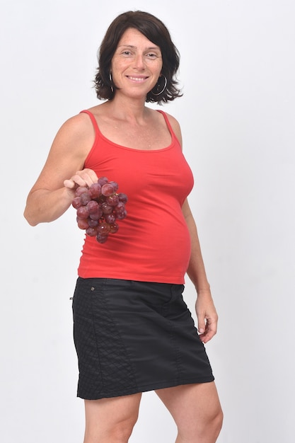 Pregnant woman holding a grape fruit on white background