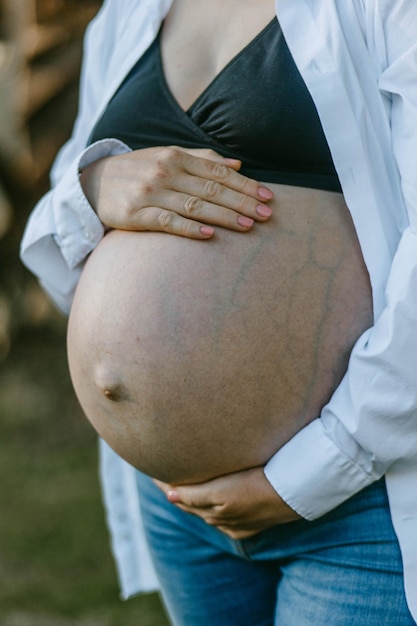 Photo a pregnant woman holding her belly close up