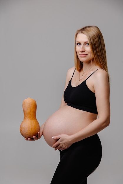 pregnant woman holding a pumpkin association with the child