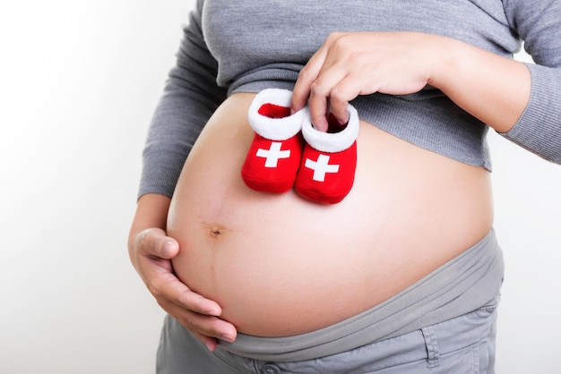 Pregnant woman holding red socks for baby