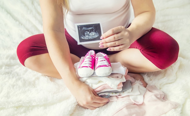 A pregnant woman holds a snapshot of an ultrasound in her hands. Selective Focus.